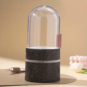 Close-up of a luxury rhinestone makeup brush holder with a clear protective dome lid