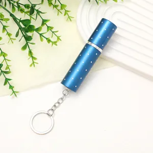 Close-up of a stylish blue 10ml mini refillable perfume atomizer with a silver keychain.