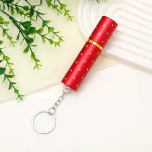 Detailed view of red refillable perfume bottle with rhinestone accents and silver keychain