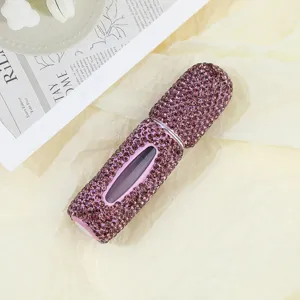 Close-up of luxury handmade purple rhinestone perfume atomizer bottle with sparkle finish.