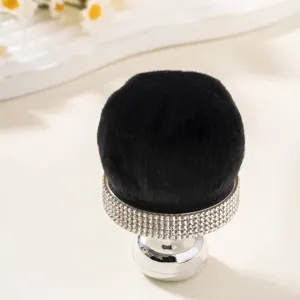 Macro view of mushroom head makeup brush with sparkling rhinestone handle.