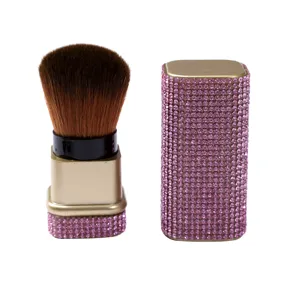 Detailed view of pink rhinestone-covered makeup brush for nail art dust and loose powder