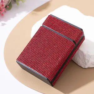 Close-up of luxury red rhinestone-encrusted cigarette case on a decorative white stone