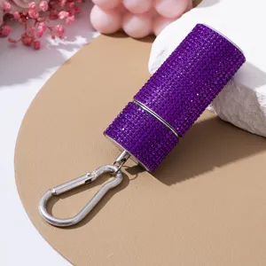 Nahaufnahme des lila Strass-Zylinderbehälters mit silbernem Karabiner-Schlüsselanhänger