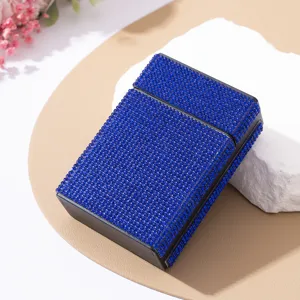 Close-up of sparkling blue rhinestone cigarette case on textured stone background
