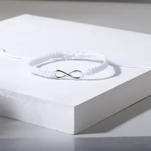 Detailansicht eines weißen handgeflochtenen Armbands mit silbernem Unendlichkeitssymbol