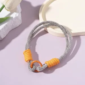 Nahaufnahme des funkelnden Strass-Handgelenkbandes mit orangen Akzenten und Metallhaken
