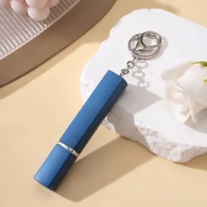 Détail macro d'un atomiseur de parfum bleu 12ml avec finition texturée et porte-clés