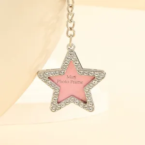 Close-up of a pink star-shaped mini photo frame keychain with rhinestone accents