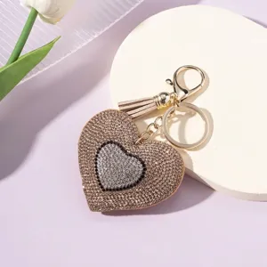 Detailed view of the sparkling rhinestone heart keychain with a stylish tan tassel.