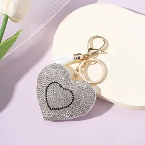 Detailed view of a sparkling heart-shaped rhinestone keychain with a white tassel.