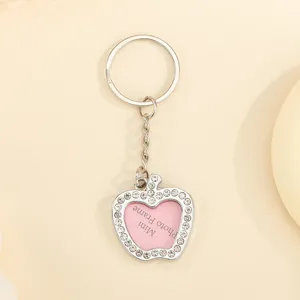 Macro detail of apple-shaped rhinestone keychain with a heart mini photo frame