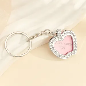 Close-up of a heart-shaped silver rhinestone keychain with a mini photo frame feature