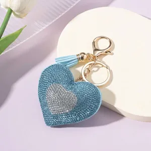 Detailed view of sparkly blue rhinestone heart keychain with gold ring and tassel