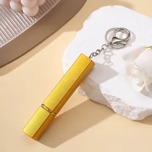 Détail d'un atomiseur de parfum doré de 12 ml avec un porte-clés argenté élégant