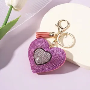 Close-up of sparkling rhinestone heart keychain with peach tassel and gold clasp