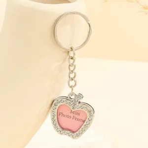 Macro view of apple-shaped rhinestone keychain featuring a mini photo frame center