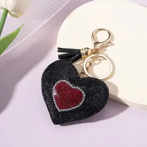 Close-up of heart-shaped keychain with black and red rhinestones and tassel