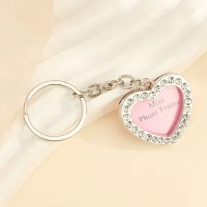 Detailed view of silver heart-shaped rhinestone keychain with mini photo frame insert
