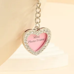 Close-up detail of the rhinestone-inlaid heart keychain featuring a mini photo frame