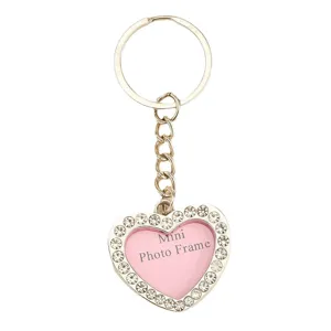 Elegant heart-shaped rhinestone keychain with mini photo frame on a white background