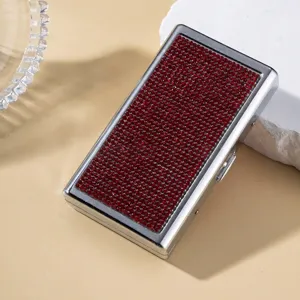 Detailed view of a luxury silver cigarette case fully adorned with glittering red rhinestones