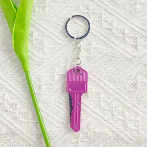 Miniature purple key-shaped folding knife keychain for opening packages outdoors