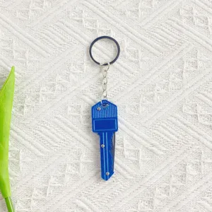 Close-up detail of a portable blue key-shaped folding knife keychain for outdoor use