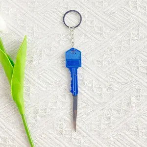 Detailed view of a mini blue key-shaped folding knife keychain for opening packages