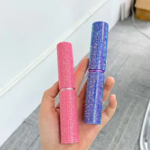 Nahaufnahme der mit rosa und blauen Strasssteinen besetzten Make-up-Pinselbehälter