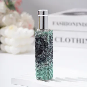 Detail view of a 10ml glass perfume spray bottle encrusted with green rhinestones