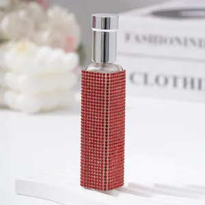 Macro view of red rhinestone-encrusted 10ml portable perfume spray bottle.