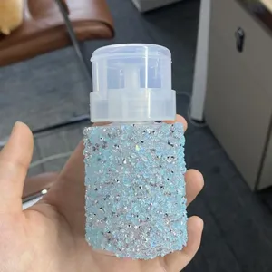 Dettaglio ravvicinato degli strass azzurri e argento su un flacone a pompa da 100 ml