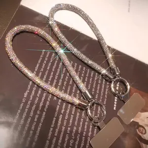 Primo piano di laccetti per telefono in strass scintillanti, finiture argento e AB