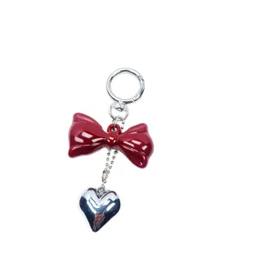 Red bow keychain with a silver heart pendant, stylish accessory for ladies' bags and keys