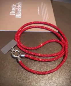 Primo piano di un cordino per cellulare di lusso in strass rossi scintillanti