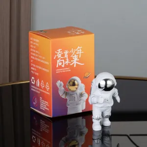 Detailed view of cute astronaut figurine and colorful packaging box for desk decor gifts.