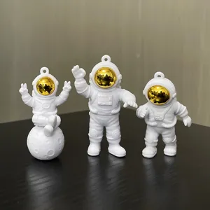 Detailed close-up of cute astronaut keychains showing fine PVC material and shiny gold visors.
