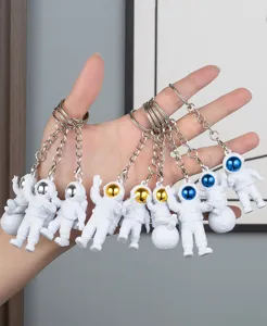Detailed view of astronaut keychains featuring electroplated visors and metal rings.