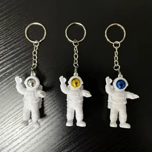 Cute astronaut keychain set with silver, gold and blue visors, ideal student gift and decor.