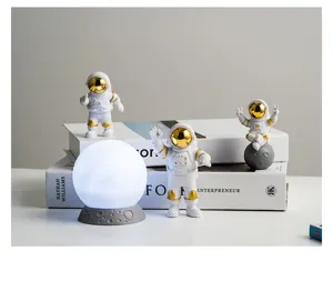 Gedetailleerd overzicht van schattige astronautenfiguren en maanlamp voor decoratie.
