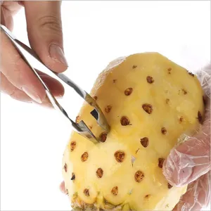 Dettaglio in primo piano del levaocchi per ananas in acciaio inossidabile, strumento in azione.