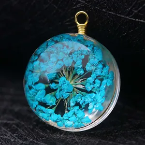 Exquisite macro detail of natural blue dried flower preserved in clear resin glass pendant