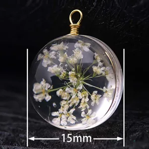 Close-up of 15mm round glass pendant featuring preserved white dried flowers inside