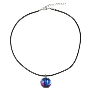 Dettaglio di un ciondolo a sfera di vetro galassia su una collana di corda nera