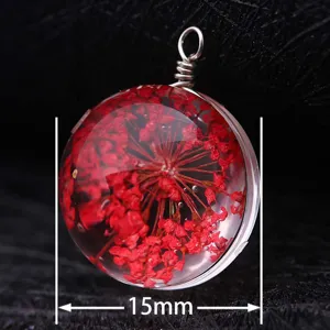 Macro view of a 15mm round glass pendant featuring delicate red dried flowers inside