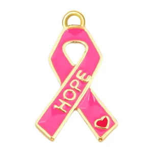 Detalle de un colgante de cinta rosa chapado en oro con el texto HOPE y un gran corazón