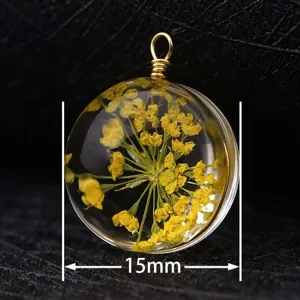 Detailed close-up view of a 15mm round glass pendant featuring yellow dried flowers inside