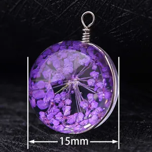 Close-up detail of a 15mm round glass pendant featuring real dried purple flowers in resin