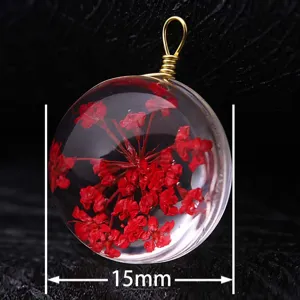 Close-up of a 15mm round glass pendant featuring preserved red dried flowers